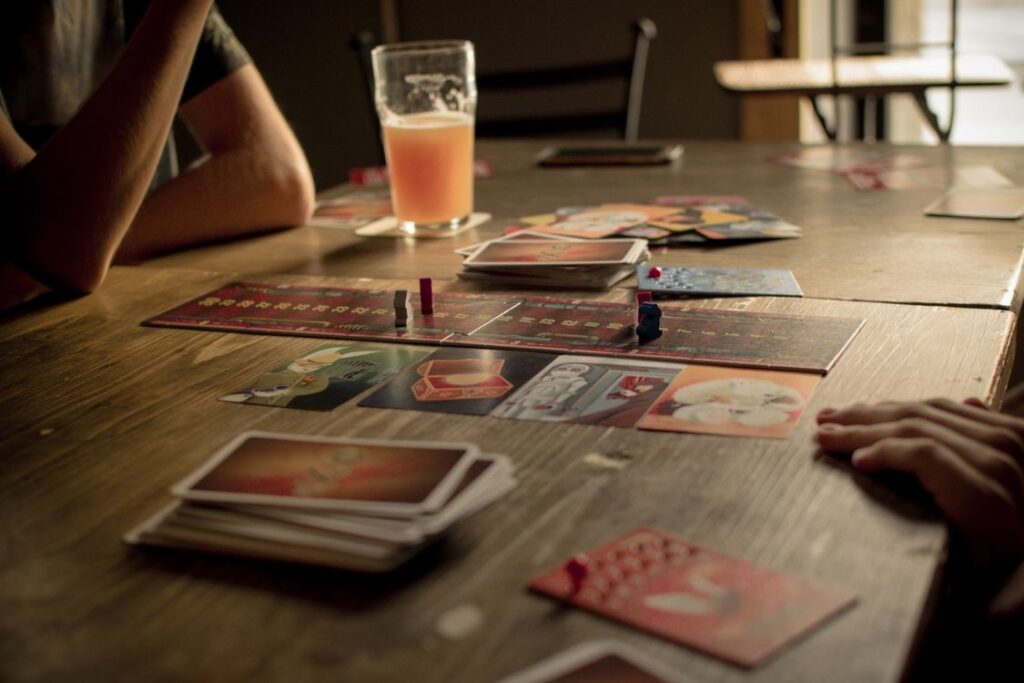 People playing a board game at a café table, capturing leisure and social interaction.